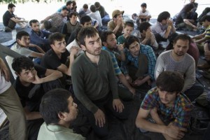 Suspected Uighurs from China's region of Xinjiang, sit inside a temporary shelter after they were detained near the Thailand-Malaysia border in Hat Yai