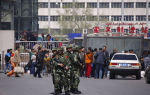 Paramilitary policemen stand guard near the exit of the South Railway Station in Urumqi
