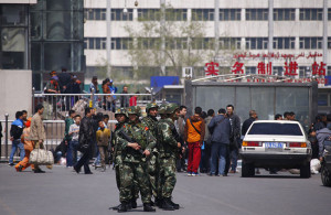 Paramilitary policemen stand guard near the exit of the South Railway Station in Urumqi