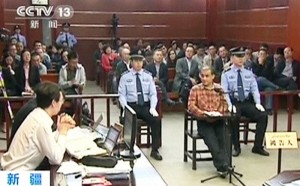 Uighur academic Ilham Tohti sits in a chair at the stand during his trial on separatism charges in Urumqi, Xinjiang region
