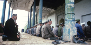 China, Xinjiang Province, Kashgar, men praying at mosque, sunset