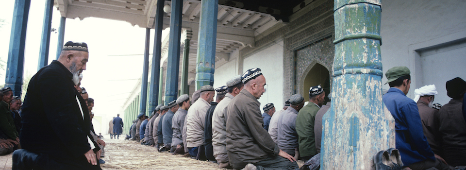 China, Xinjiang Province, Kashgar, men praying at mosque, sunset