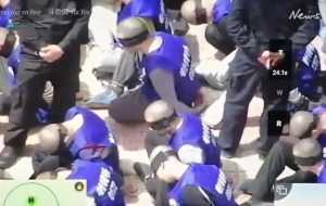 Потрясающее видео показывает, что китайская полиция переводит сотни заключенных с завязанными глазами