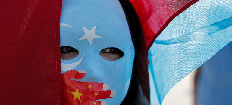 An ethnic Uighur demonstrator wears a mask as she attends a protest against China in front of the Chinese Consulate in Istanbul